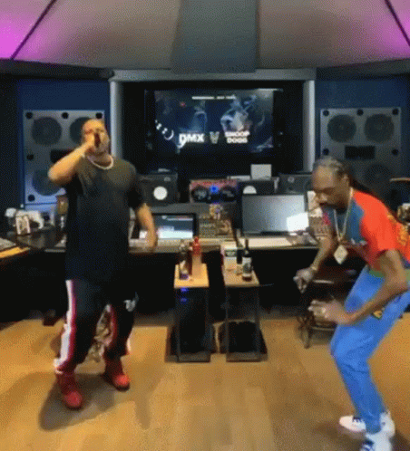 A Couple Of Men Are Standing Next To Each Other In A Room And Dancing . GIF