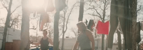 A Couple Of Men Are Standing Next To Each Other In Front Of A Clothes Line . GIF