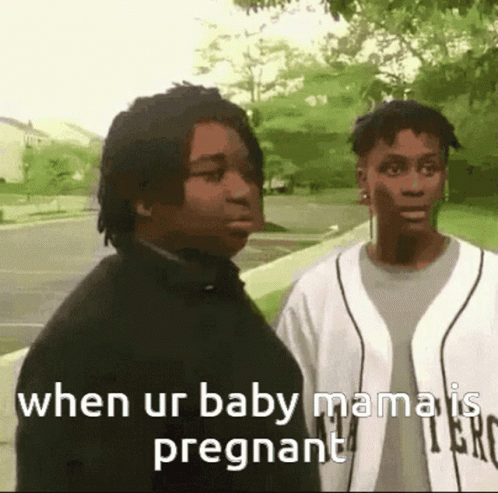 a couple of men are standing next to each other on a sidewalk and one of them is pregnant .