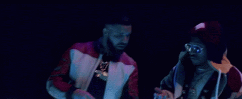 A Couple Of Men Are Standing Next To Each Other On A Stage . GIF