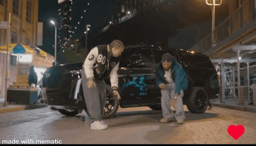 A Couple Of Men Standing Next To A Car With The Number 80 On It GIF
