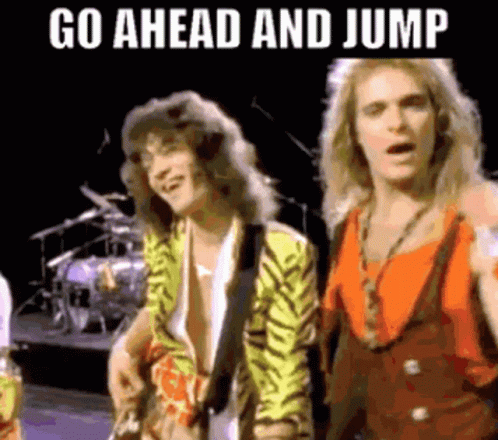 A Couple Of Men Standing Next To Each Other On A Stage With The Words `` Go Ahead And Jump '' Written Above Them . GIF