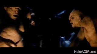 A Couple Of Monsters Standing Next To Each Other In The Dark . GIF