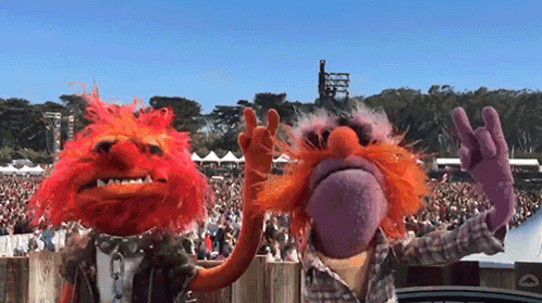 A Couple Of Muppets Standing Next To Each Other GIF