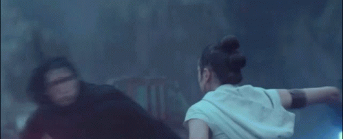 A Couple Of People Are Fighting With Lightsabers In The Dark . GIF