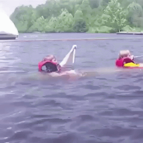 A Couple Of People Are Floating In The Water . GIF