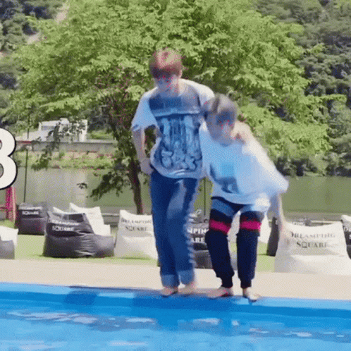 A Couple Of People Are Standing Next To Each Other In A Pool . GIF