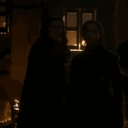 A Couple Of People Standing In A Dark Room With The Words What Do We Say To The God Of Death GIF