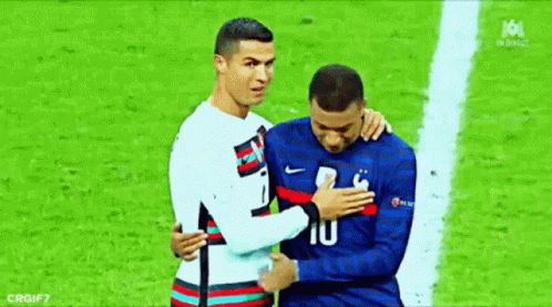 A Couple Of Soccer Players Are Hugging Each Other On A Field . GIF
