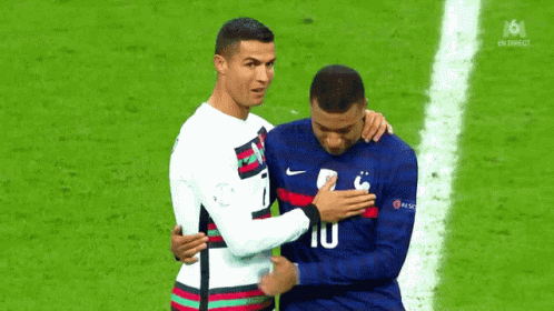 A Couple Of Soccer Players Are Hugging Each Other On A Field . GIF