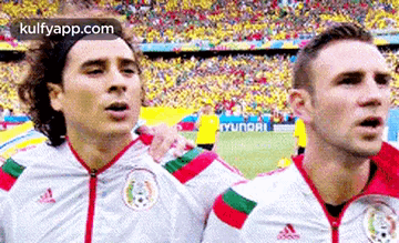 A Couple Of Soccer Players Are Standing Next To Each Other On A Field . GIF