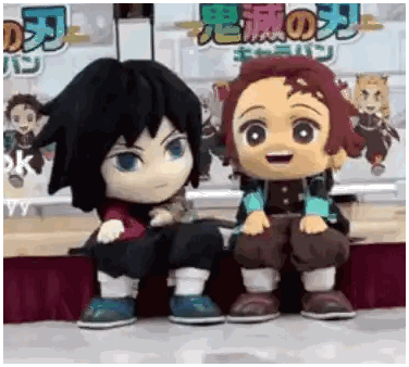 a couple of stuffed dolls sitting next to each other on a stage .