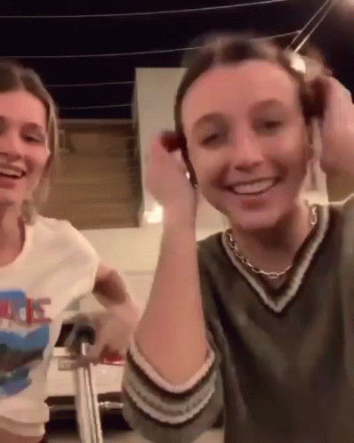 A Couple Of Women Are Standing Next To Each Other And Smiling . GIF