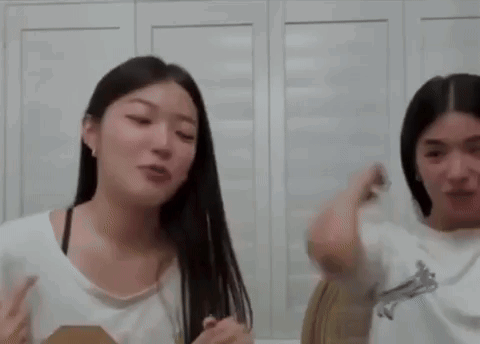 A Couple Of Women Are Standing Next To Each Other In A Room . GIF