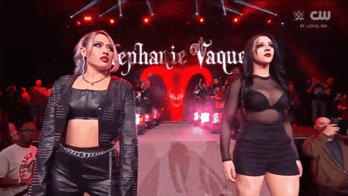 A Couple Of Women Standing On A Stage With The Name Stephanie Vaque Written On It GIF