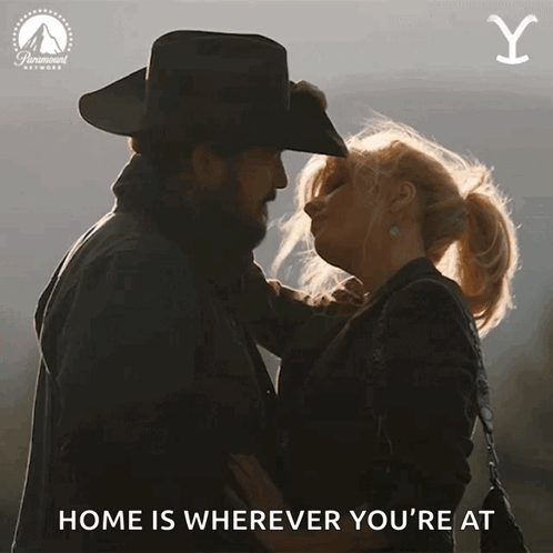 A Cowboy And A Woman Are Kissing With The Words " Home Is Wherever You 'Re At " GIF