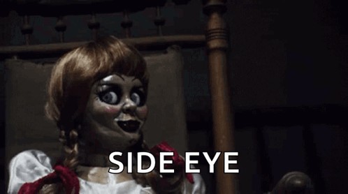 A Creepy Doll Is Sitting In A Chair With The Words `` Side Eye '' Written Below Her . GIF