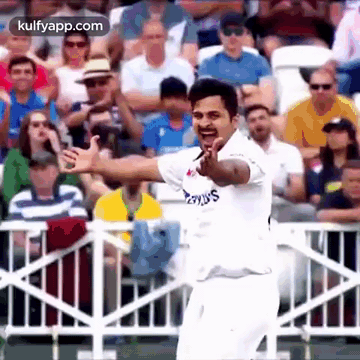 a cricket player is giving a thumbs up in front of a crowd .