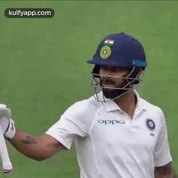A Cricket Player Wearing A Helmet And A White Shirt . GIF