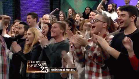 A Crowd Of People Applauding In Front Of Jerry Springer 25 GIF