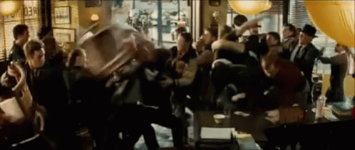 A Crowd Of People Are Gathered In A Room With A Sign That Says " Check Out " GIF