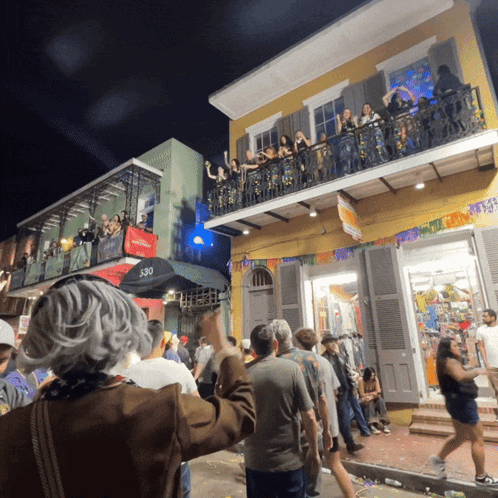 A Crowd Of People Are Gathered Outside A Building With The Number 530 On The Side GIF