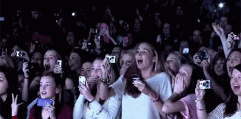 A Crowd Of People Are Taking Pictures With Their Cell Phones At A Concert . GIF