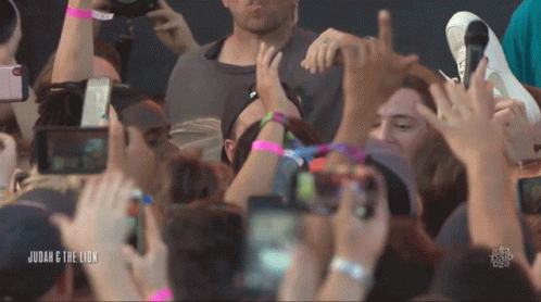 A Crowd Of People At A Concert With The Words Judah & The Lion Below Them GIF