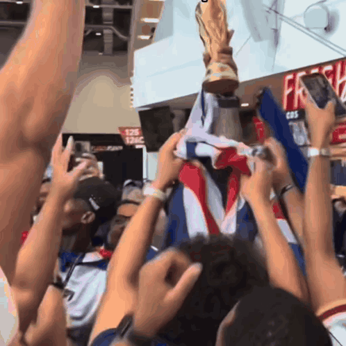 A Crowd Of People Holding A Trophy In Front Of A Sign That Says 126 GIF