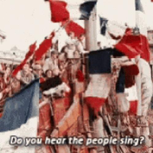A Crowd Of People Holding Flags With The Words Do You Hear The People Sing Below Them GIF