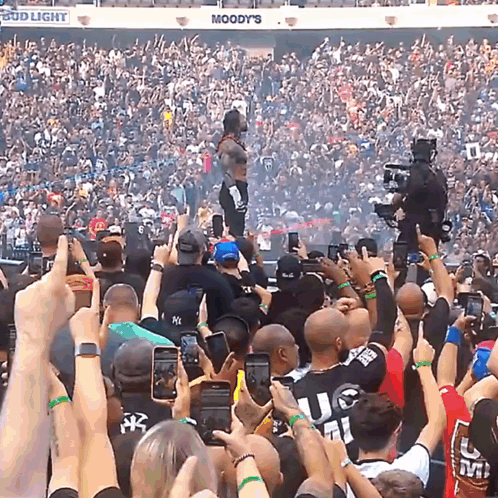A Crowd Of People In A Stadium With A Bud Light Sign Above Them GIF