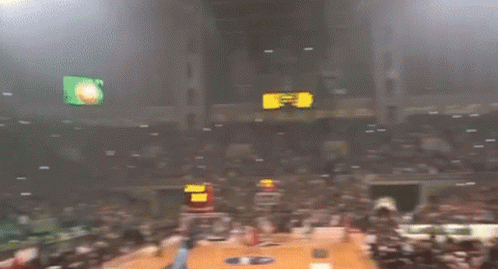 A Crowd Of People In A Stadium With Smoke Coming Out Of The Stands And A Sign That Says ' A ' GIF