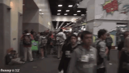 A Crowd Of People Walking In A Hallway With The Words Funny On The Bottom Right GIF