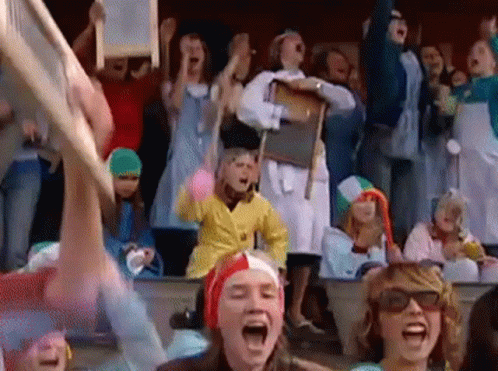 A Crowd Of People Wearing Costumes Are Screaming And Cheering GIF