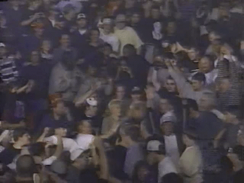 A Crowd Of People With Their Hands In The Air Including A Man Holding A Sign That Says ' A ' GIF