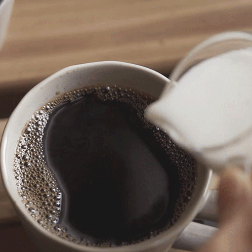 A Cup Of Coffee Is Being Poured Into Another Cup GIF