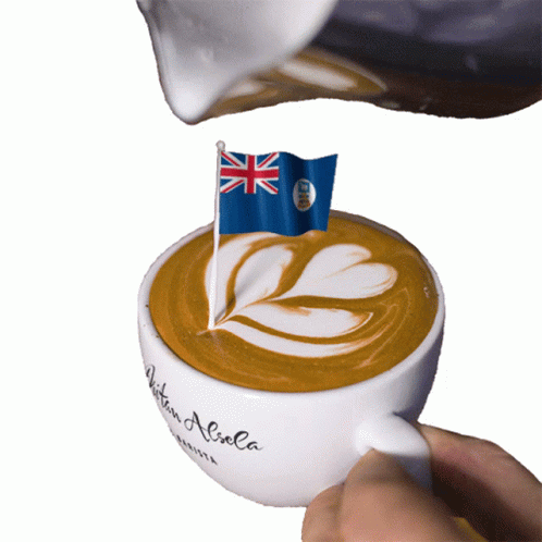 A Cup Of Coffee Is Being Poured With A British Flag On Top GIF