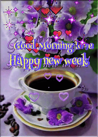 A Cup Of Coffee Sits On A Saucer With Purple Flowers In The Background GIF