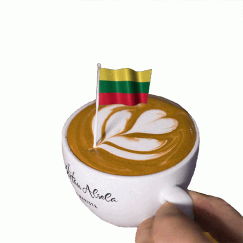 A Cup Of Coffee With A Small Flag On Top Of It GIF