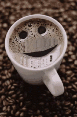 A Cup Of Coffee With A Smiley Face On The Top GIF