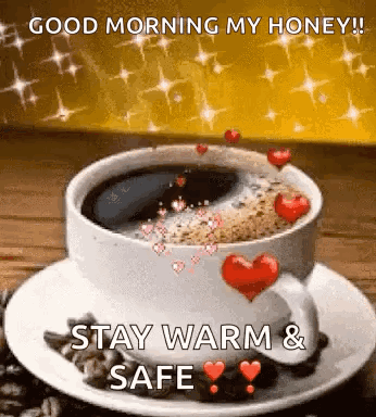A Cup Of Coffee With Hearts On It Is On A Saucer On A Table . GIF