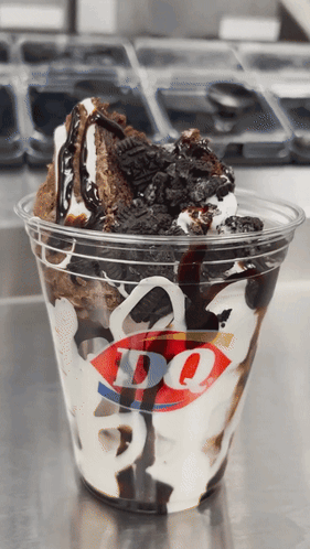 A Cup Of Dq Ice Cream With Oreos And Chocolate Sauce GIF