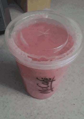 A Cup Of Pink Liquid With A Clear Lid And A Chinese Symbol On It GIF