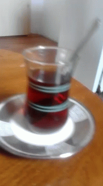 A Cup Of Tea Is On A Saucer On A Table GIF
