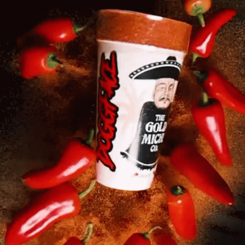 A Cup That Says ' The Gold Mich Co ' On It Surrounded By Red Peppers GIF