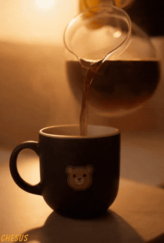 A Cup With A Teddy Bear On It Is Being Poured GIF