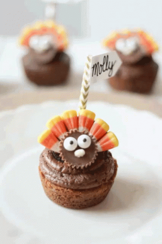 A Cupcake With A Peanut Butter Cup In The Shape Of A Turkey And A Name Tag That Says Molly GIF
