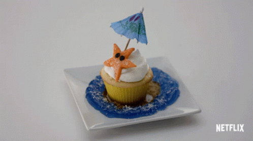 A Cupcake With A Starfish And An Umbrella On Top Of It On A White Plate With Netflix Written On The Bottom GIF