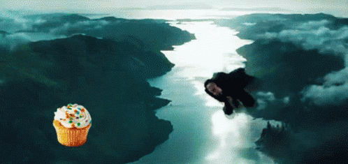 A Cupcake With Sprinkles Is Flying Over A River GIF