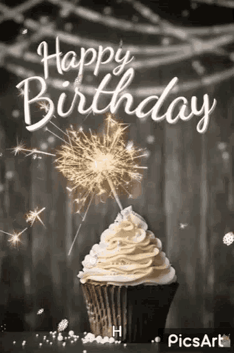 A Cupcake With Whipped Cream And A Sparkler On Top Of It . GIF
